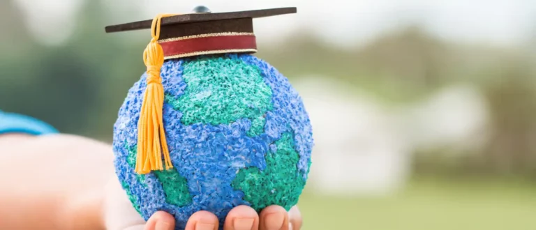 Mini globe dons graduation cap, symbolizing global education and international schools.
