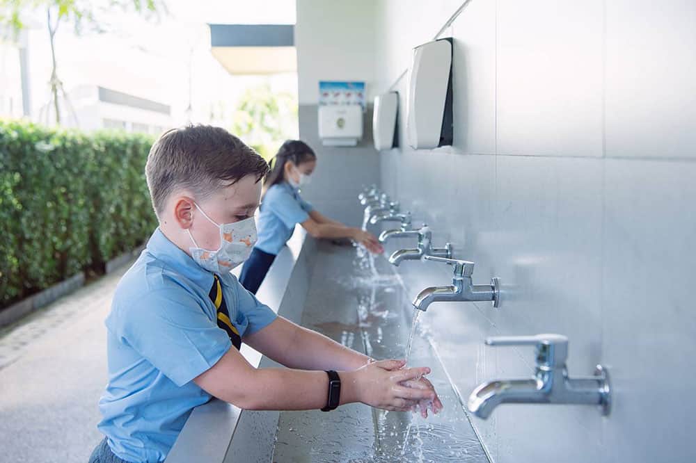 Students wash their hands and follow safety procedures