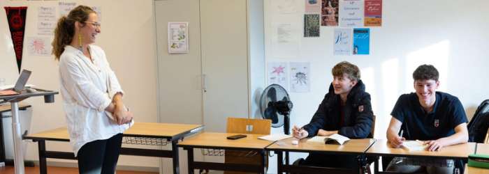 Latest news from TASIS - October, 2022 13 Diverse group of students in classroom engaging with instructor, fostering global learning experiences.