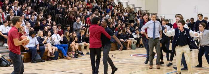 Latest news from TASIS - October, 2022 25 Students enjoying a lively school assembly in a gymnasium with engaged teachers and a large attentive audience.