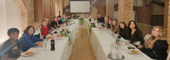 Latest news from TASIS - October, 2022 26 Diverse group of students attending a World Schools conference in a modern, brick-walled venue for international education.