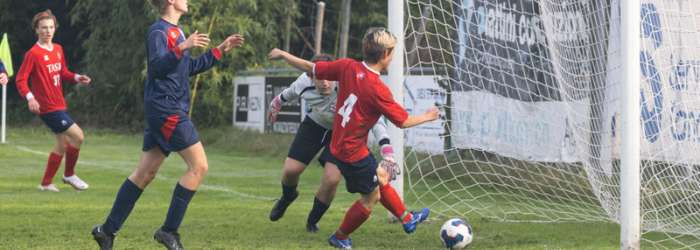 Latest news from TASIS - October, 2022 20 Young soccer players competing in a match on a lush green field, capturing school sports excellence and competitive spirit.