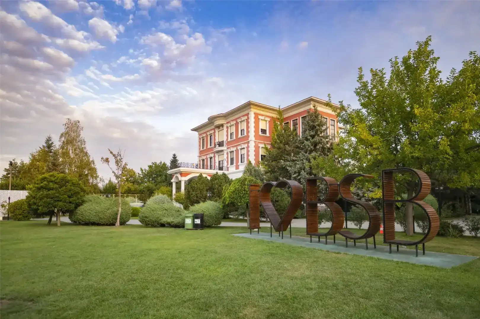 High school building at World Schools campus with lush greenery and modern architecture.