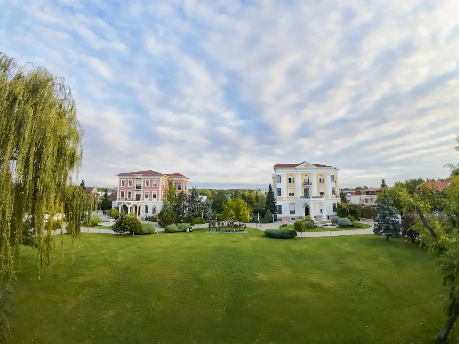 Modern school buildings with lush green lawns and scenic surroundings at World Schools campus.