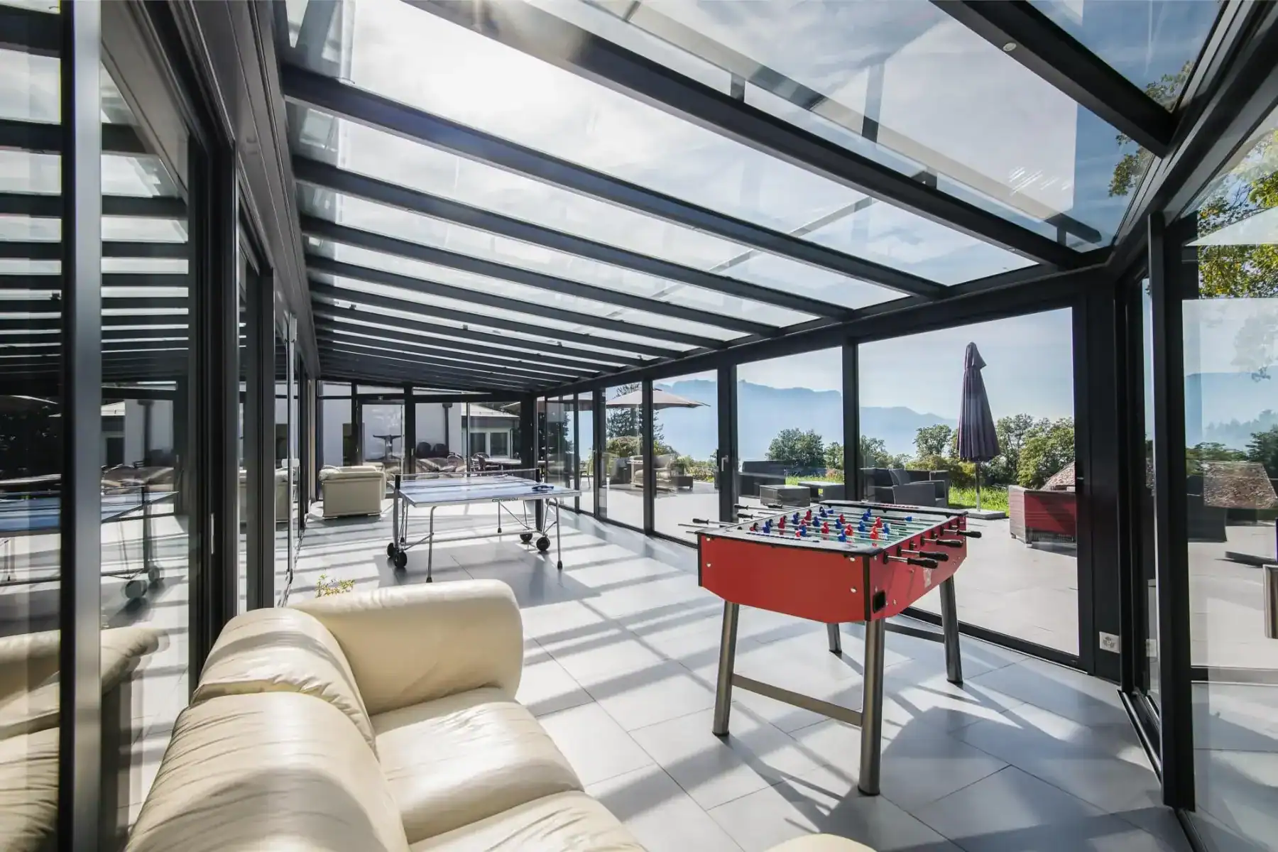 Bright indoor space with panoramic views, featuring a foosball table and comfortable seating for stu.