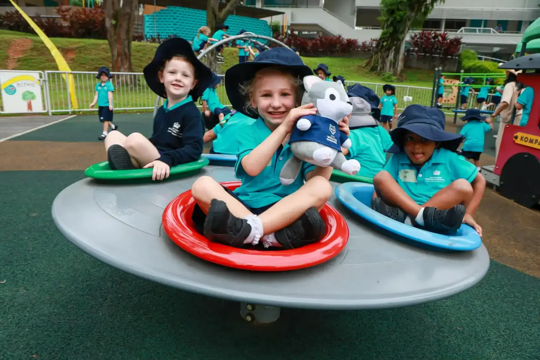 Children playing on a merry-go-round at Dover Court International School playground.