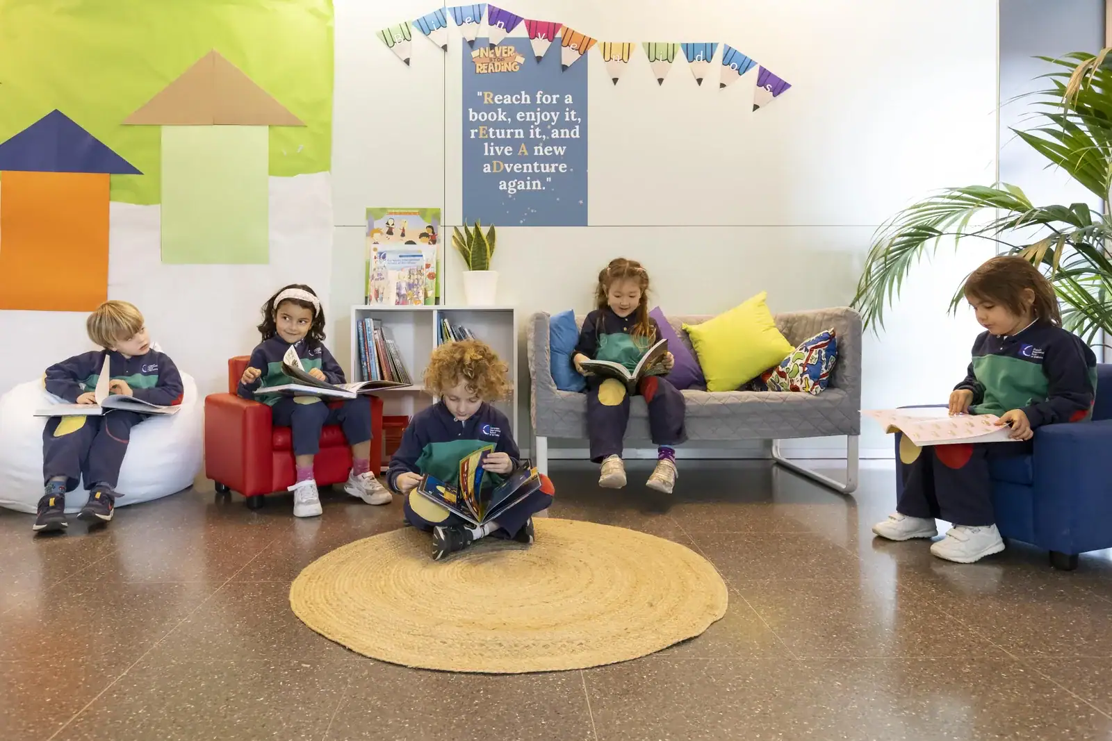 Group of young students reading books in a bright school lounge.