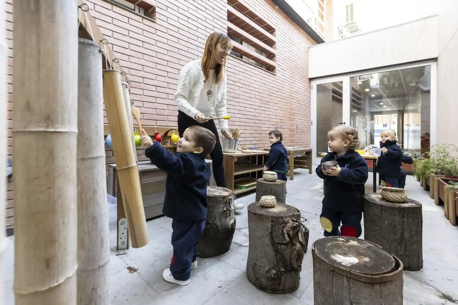 Children at World Schools engaging with outdoor learning activity under teacher supervision.