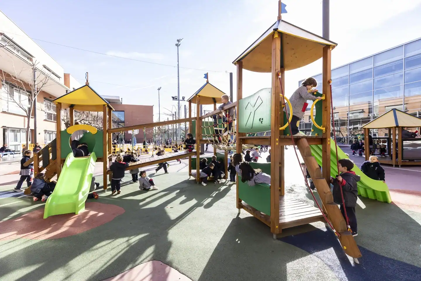 Children playing on a colorful outdoor playground at European International School of Barcelona.
