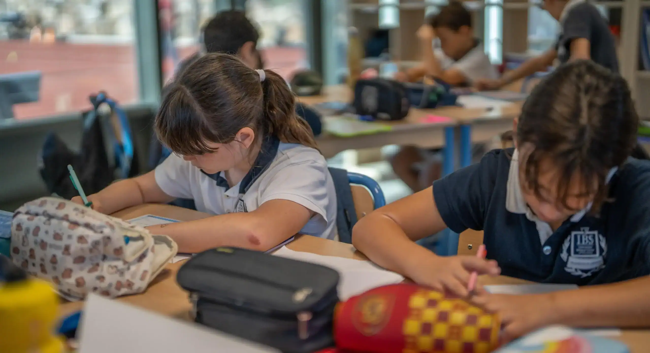 Focused students studying in a modern classroom at a world school, emphasizing global education and academic excellence.