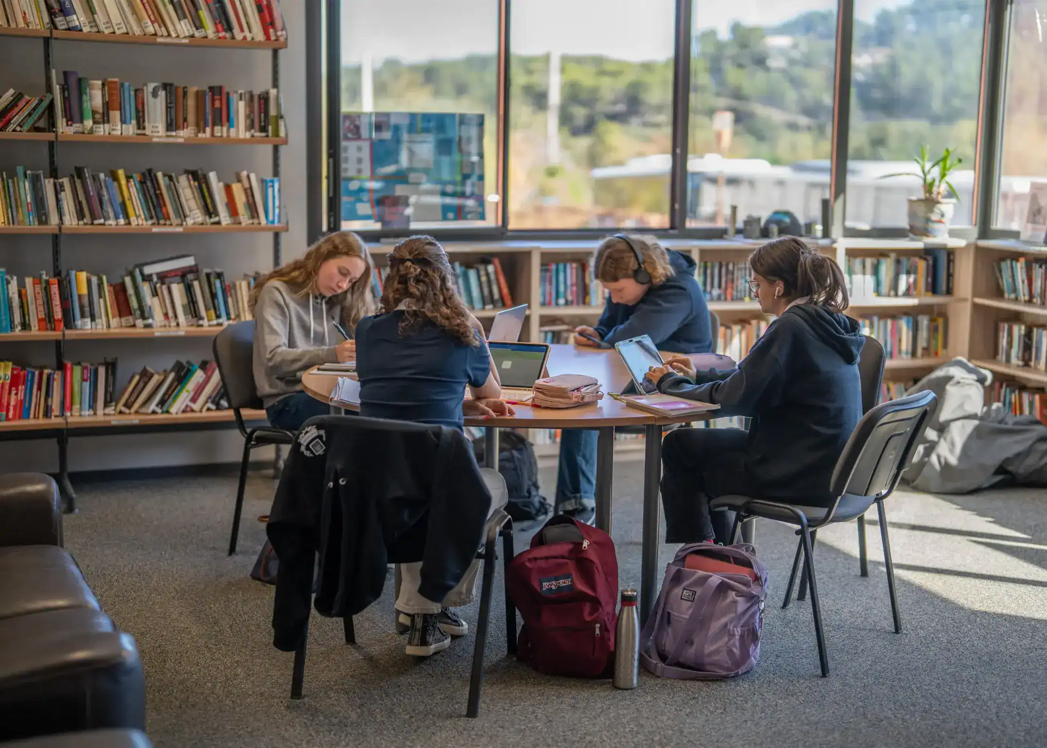 Focused students studying and working in a modern library with educational resources at World Schools.