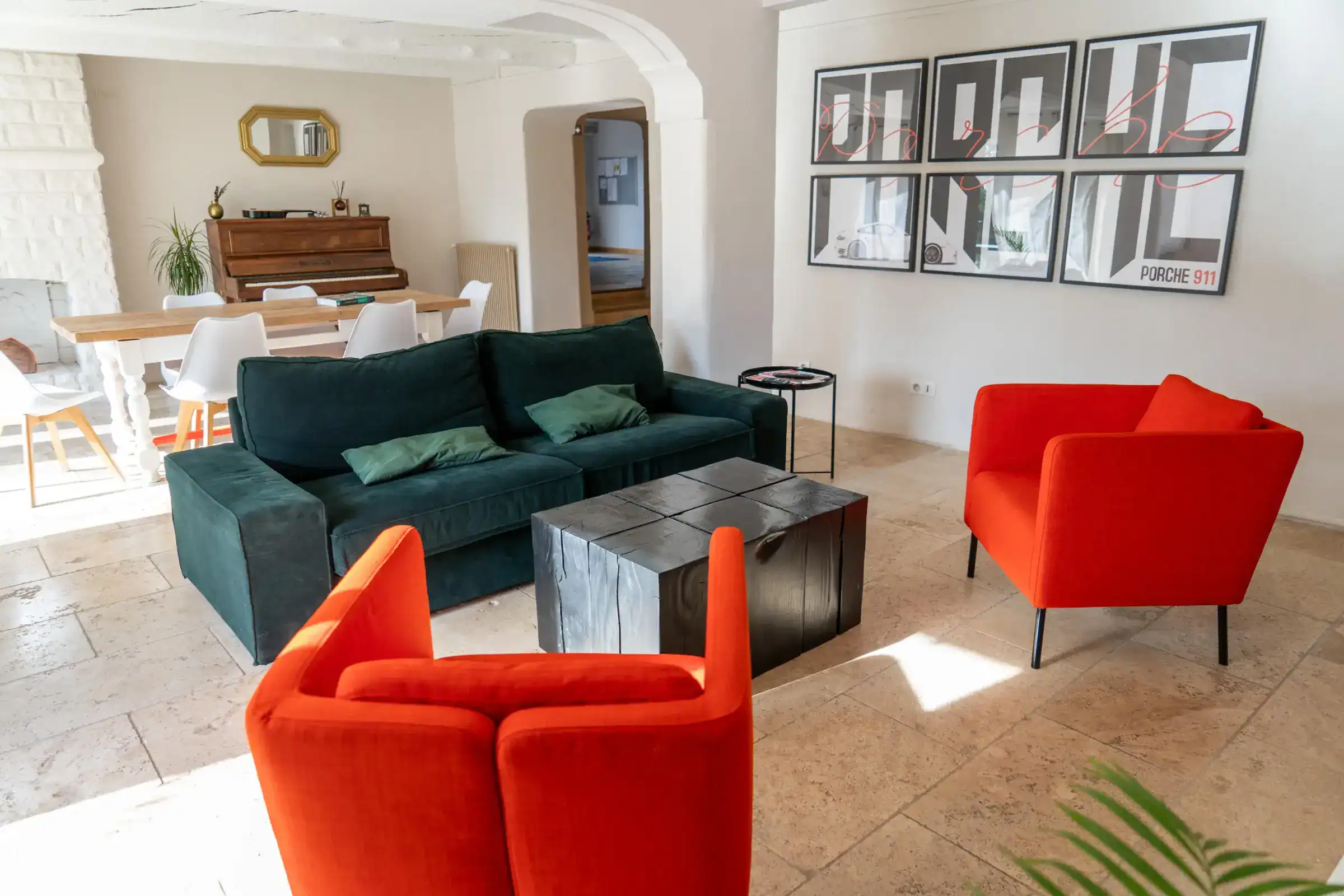 Cozy modern living room with vibrant orange chairs and stylish artwork, ideal for students' relaxation and socializing.