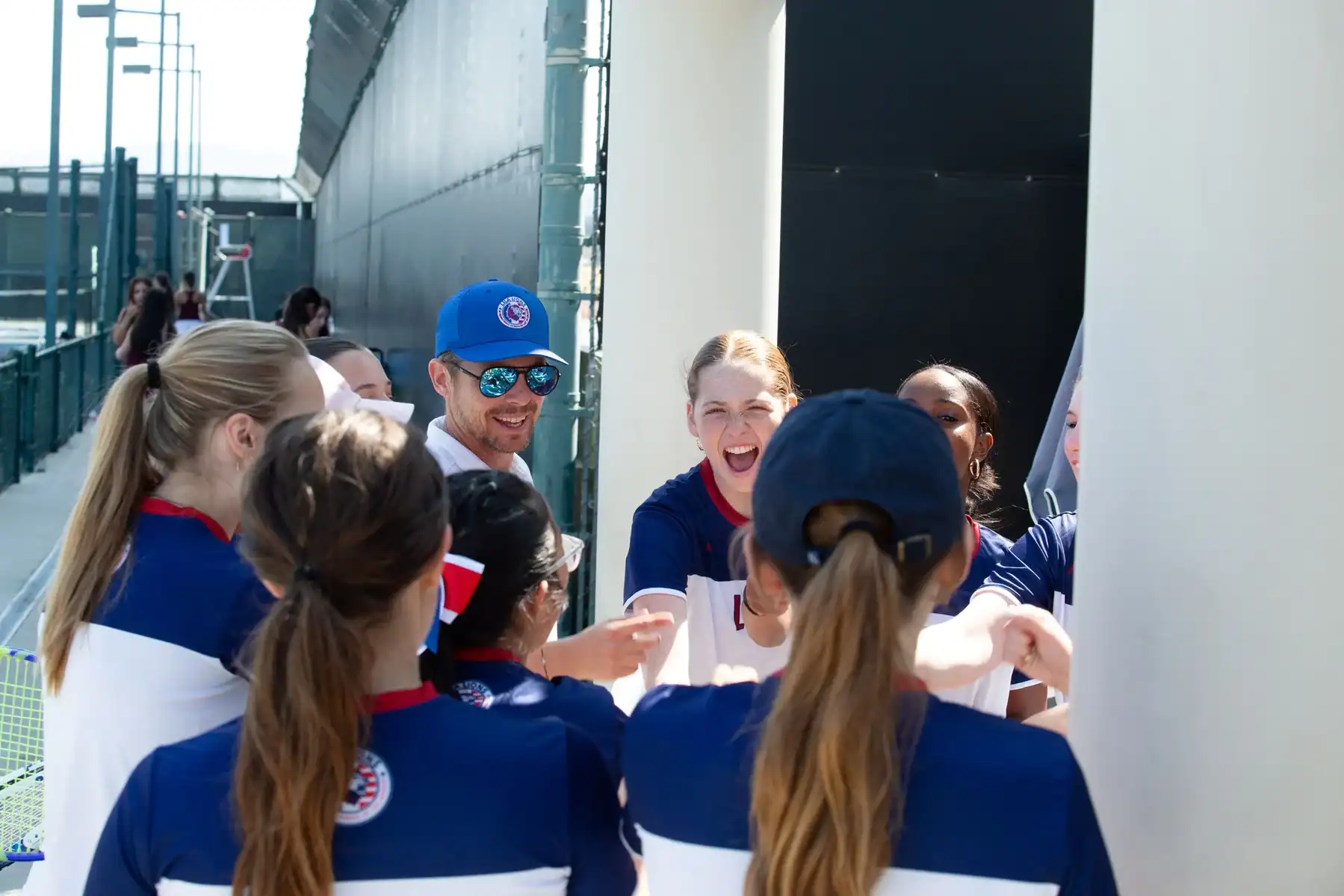 World Schools team in blue and white uniforms cheering together.