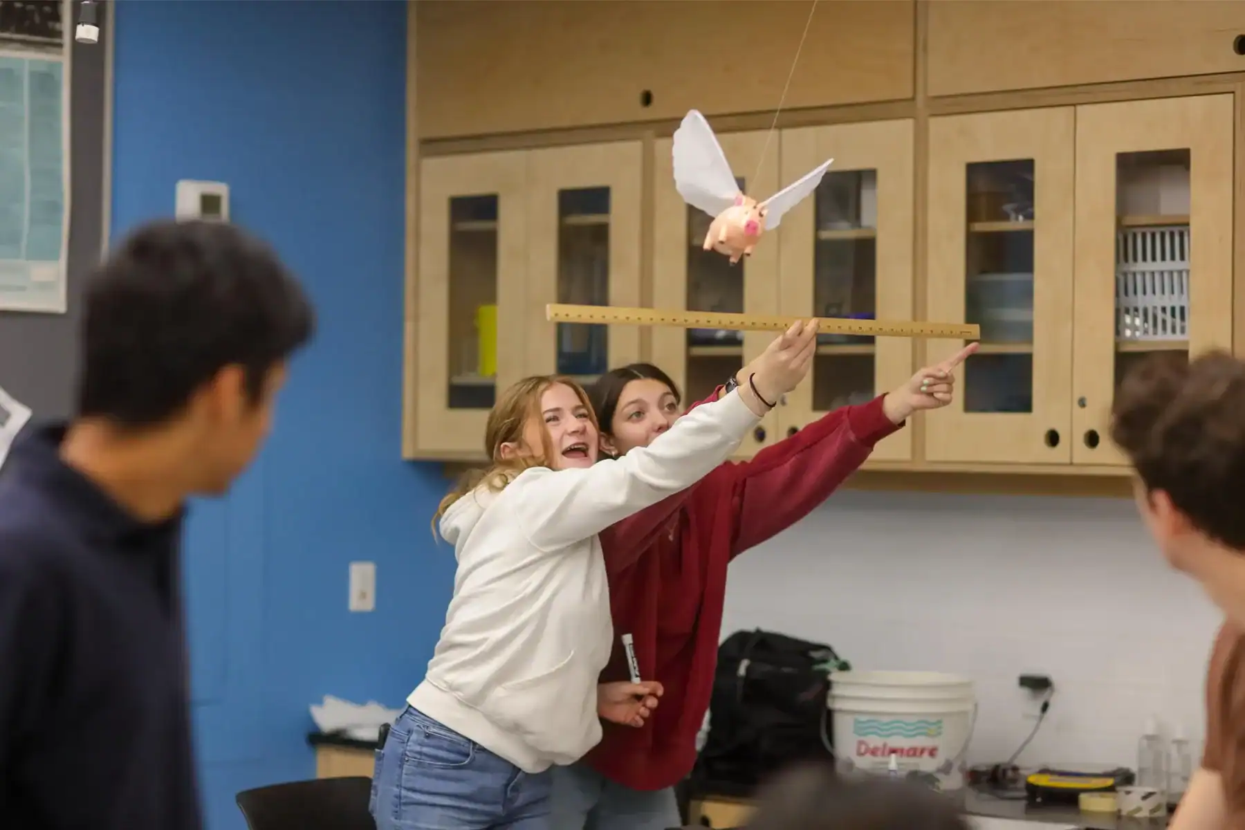 Engaging students in a hands-on science experiment with a flying model bird in a classroom setting.