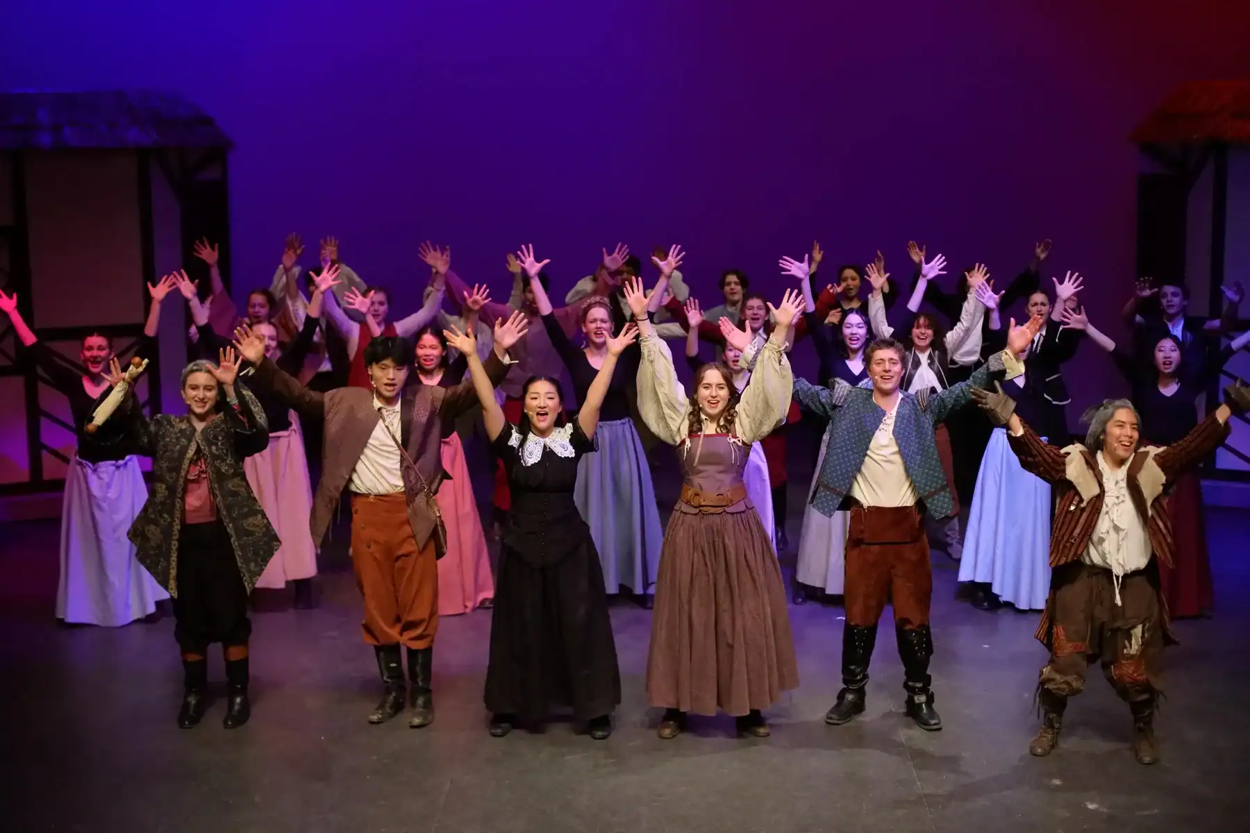 Students performing on stage in historical costumes at Lakefield College School.