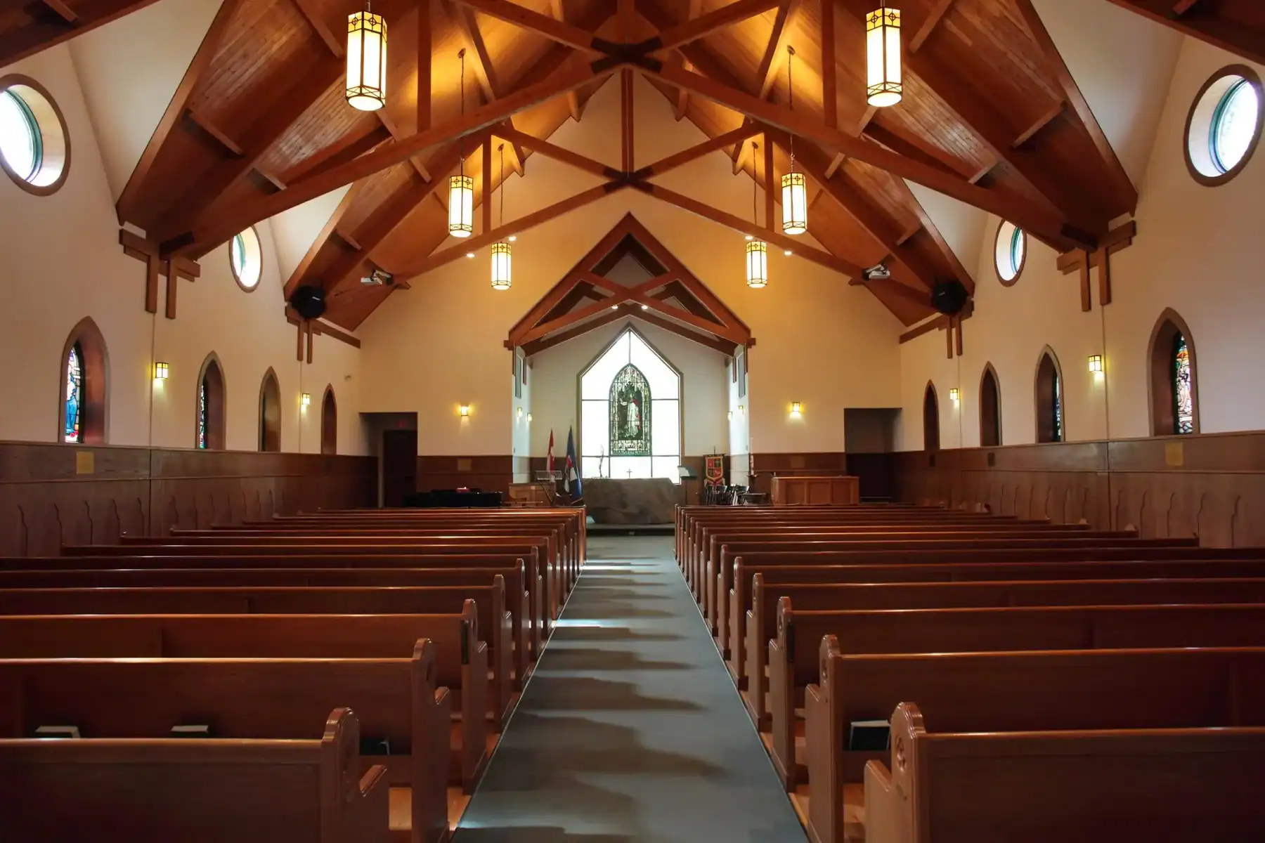 Church interior at Lakefield College School with wooden pews and stained glass windows.