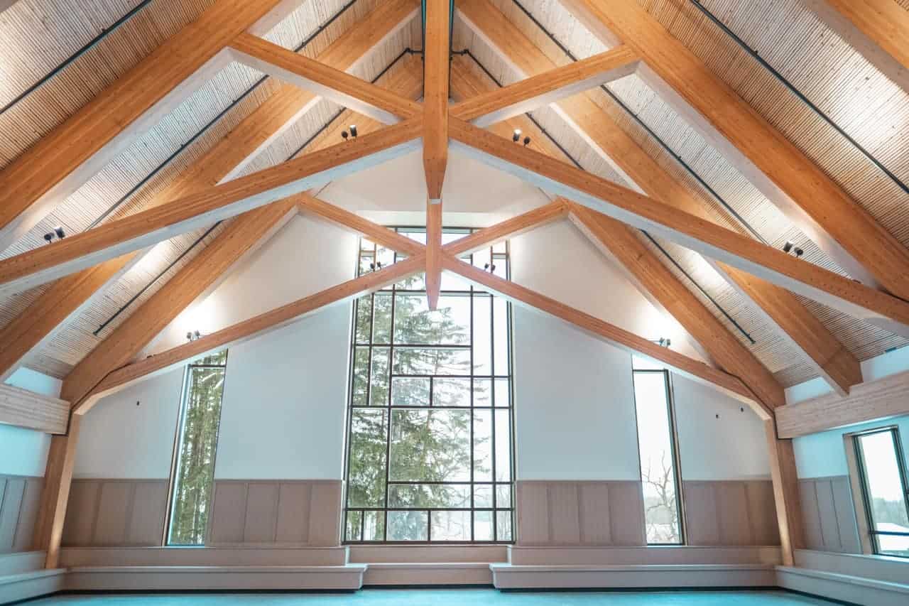 Indoor sports hall with wooden beams and large windows at Lakefield College School.