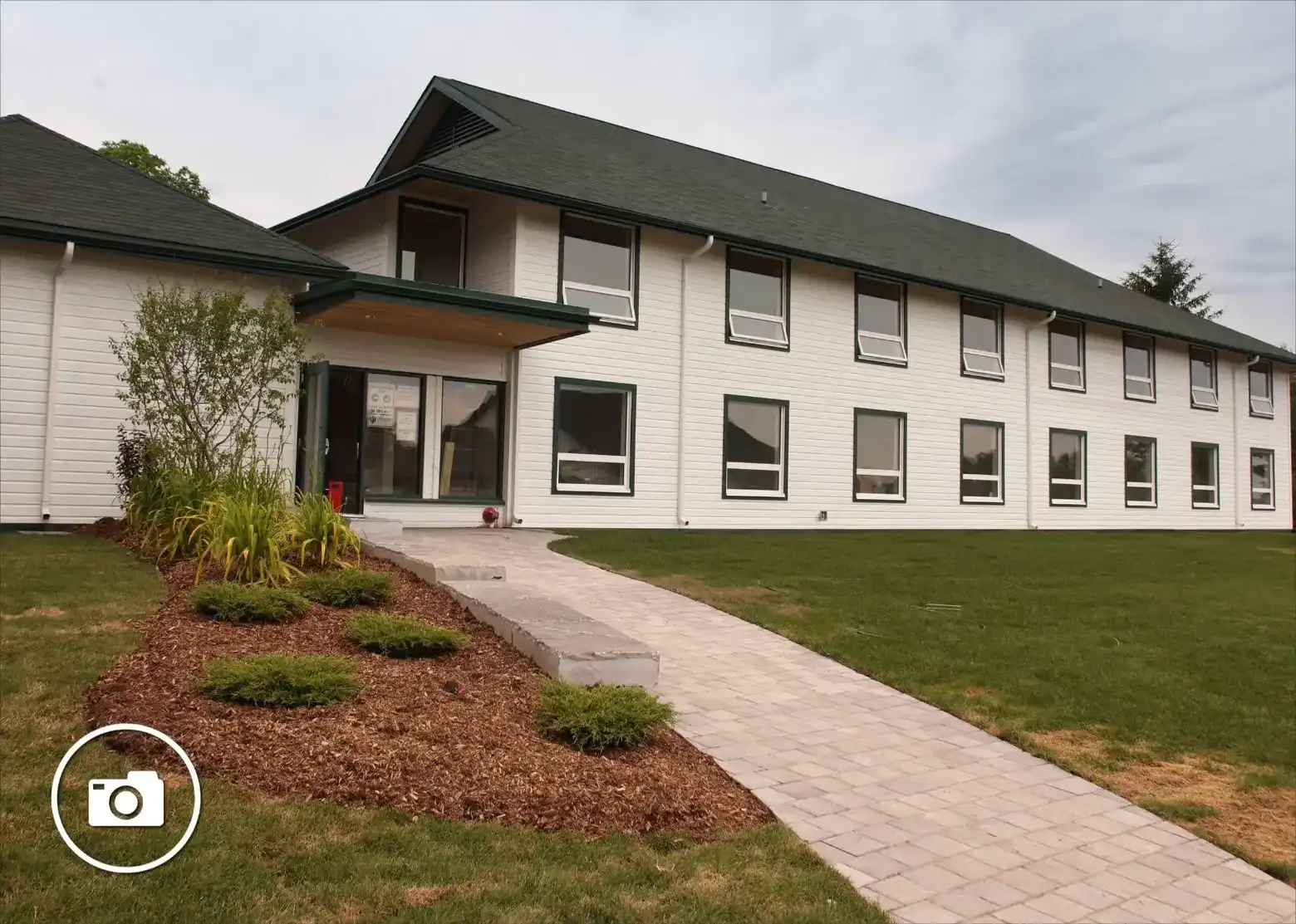 School building with landscaped entrance and green lawn.