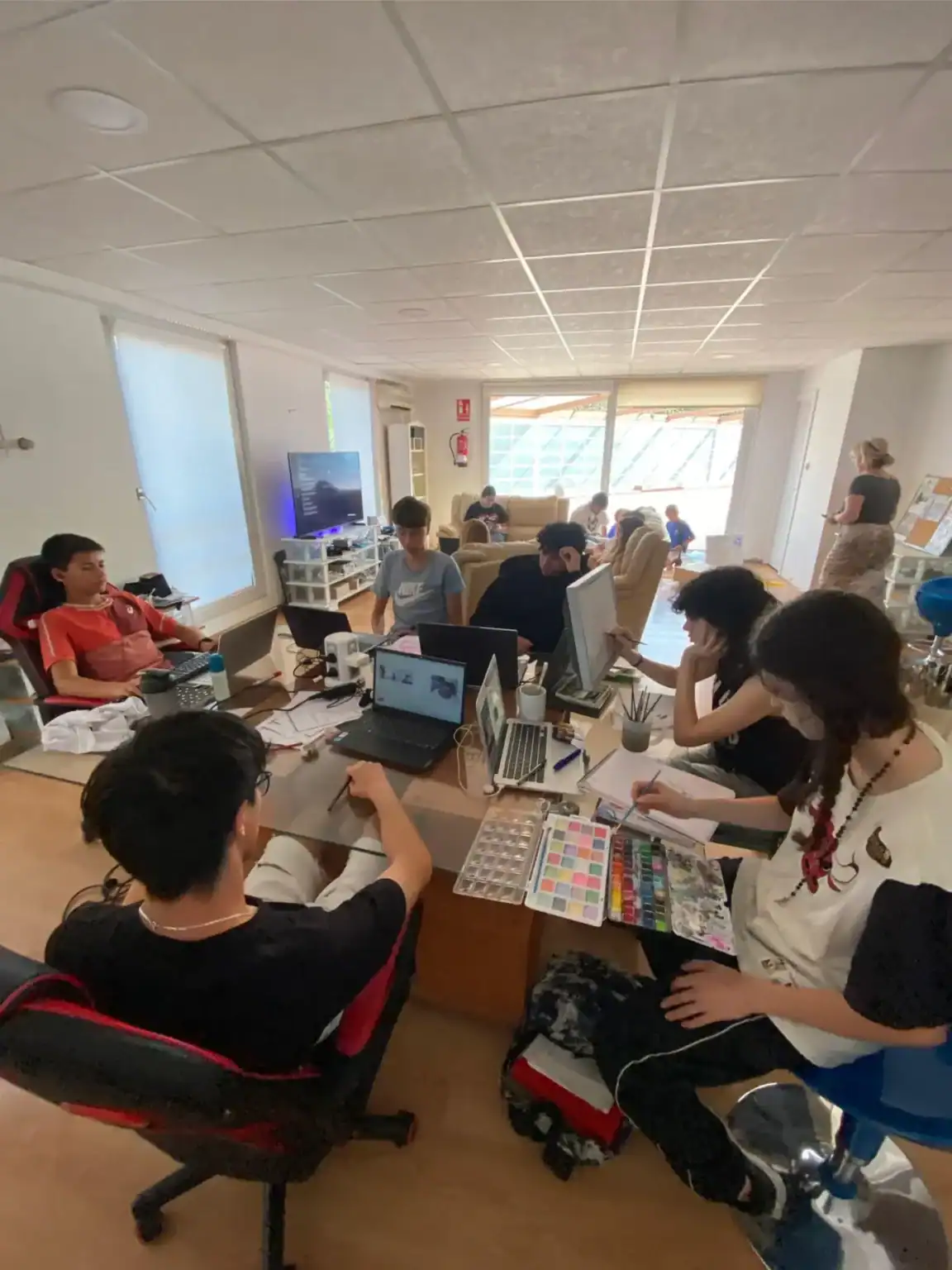 Laptops and tablets in use at a modern classroom with students engaged in digital learning activities.