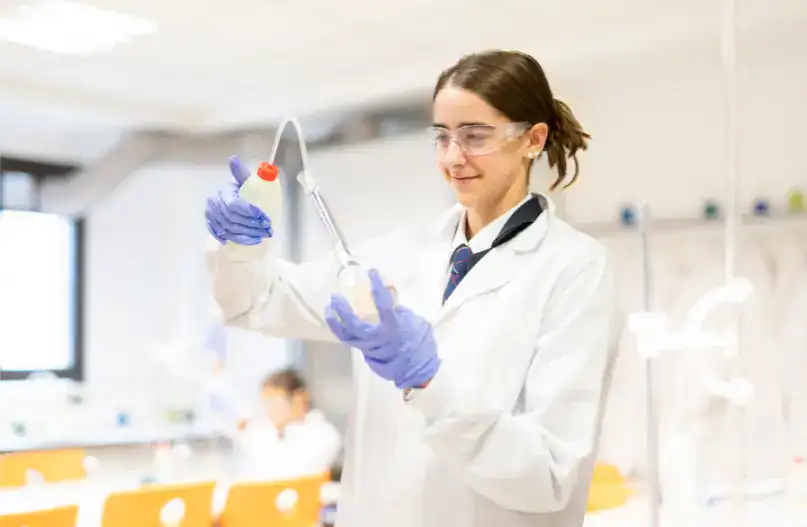 Student conducting a science experiment in a laboratory at Thames British School.