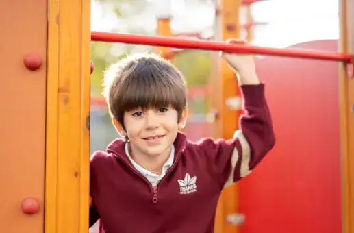 Young boy playing on playground equipment at Thames British School Madrid.