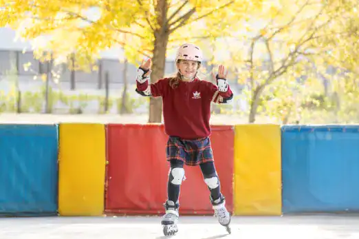 Child roller skating outdoors with safety gear at Thames British School Madrid.