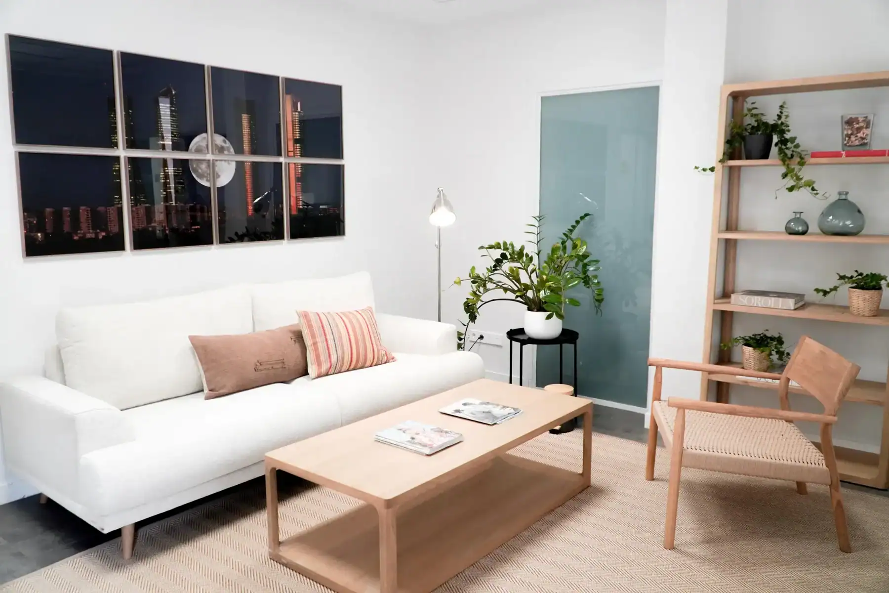 Spacious living room featuring a white sofa, wooden coffee table, and stylish shelving unit.
