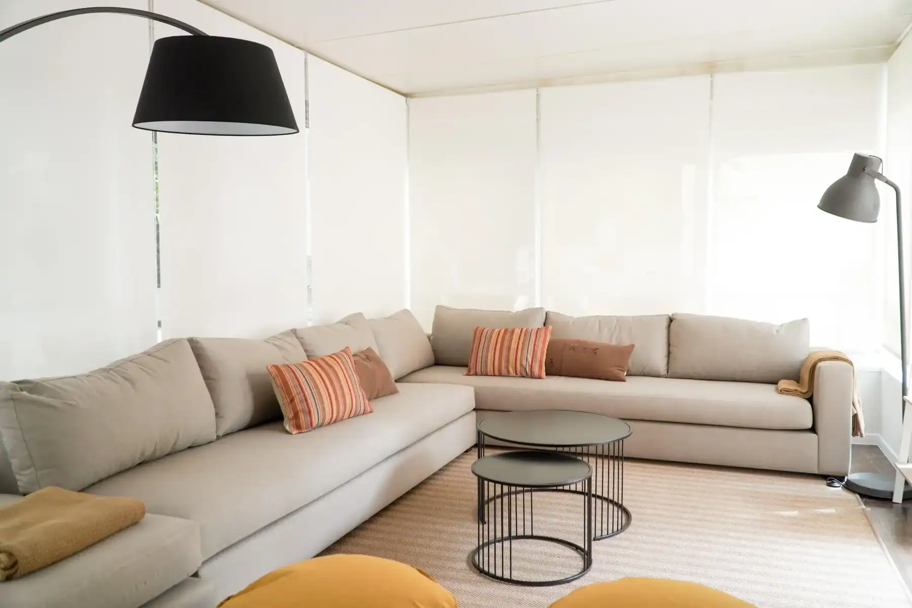 Comfortable contemporary lounge with beige sofas and colorful cushions.