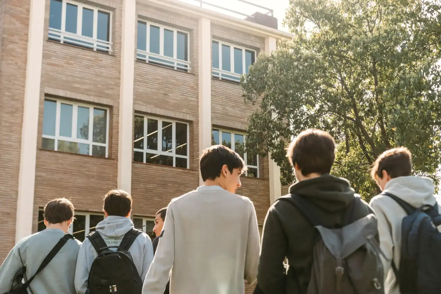 School students entering a modern educational building.