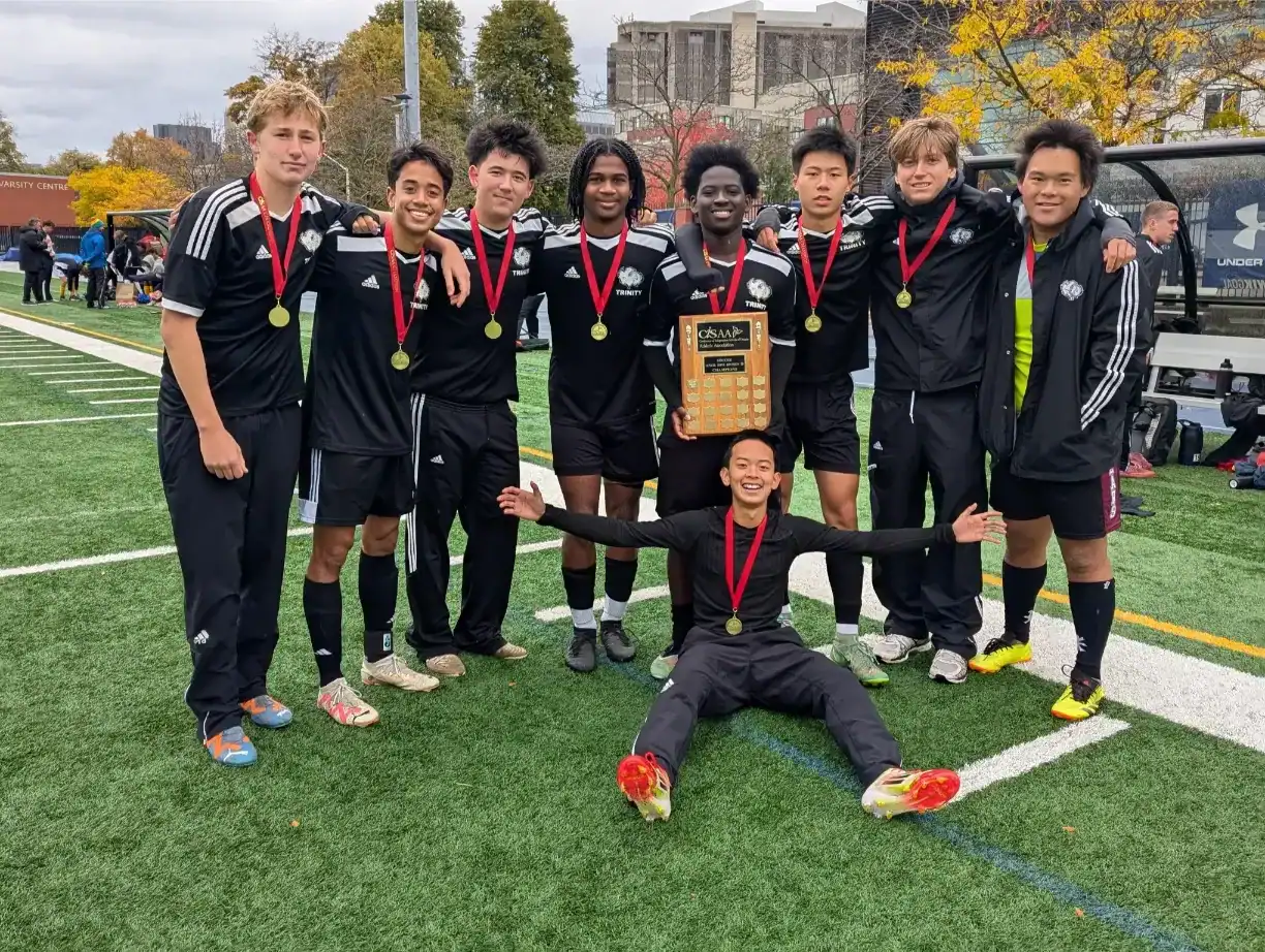 Youth soccer team with medals celebrating victory on field.