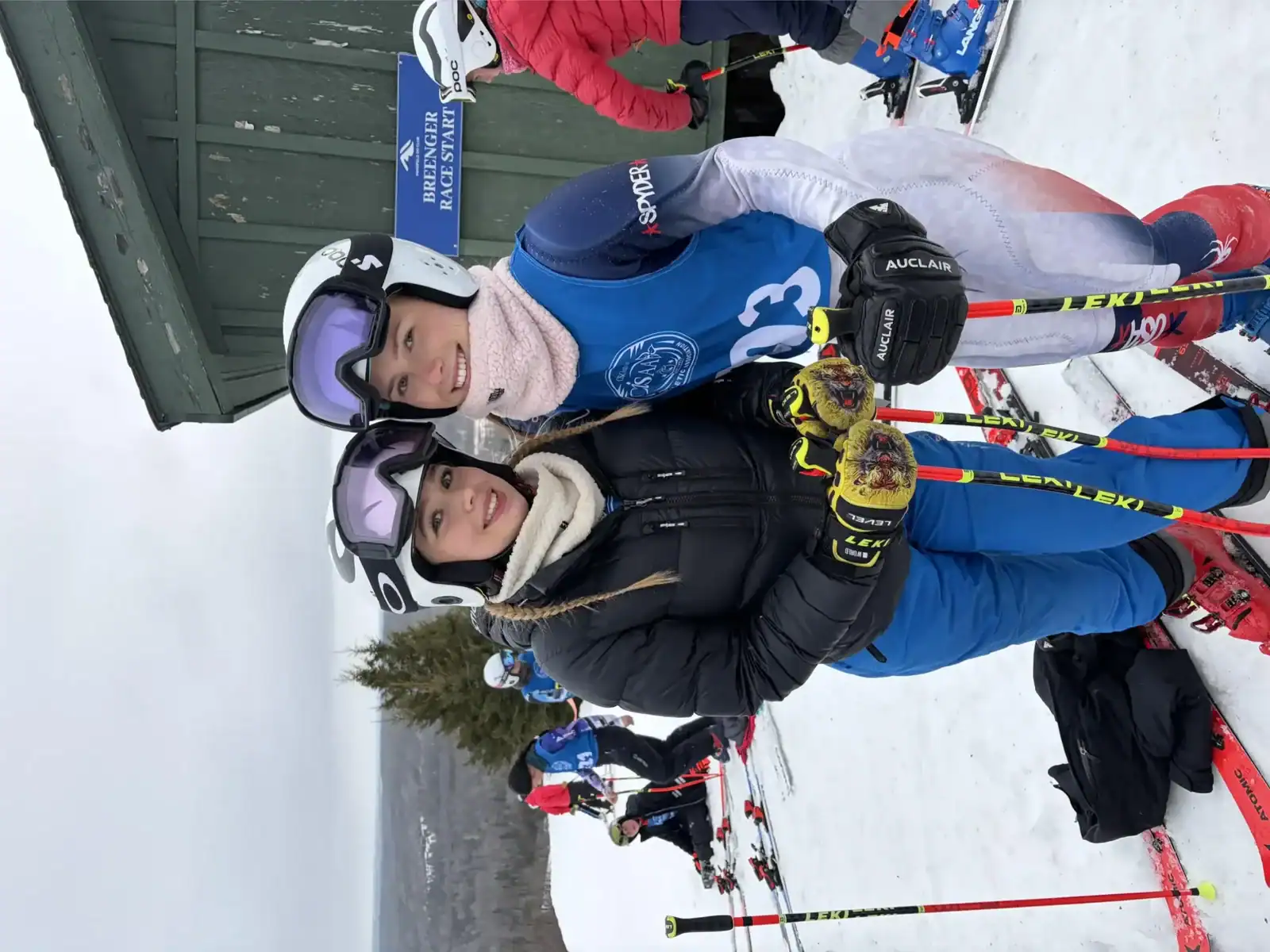 Two young skiers in winter gear at a ski resort with snow and ski equipment.