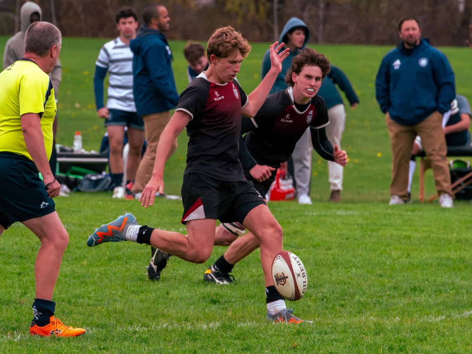 Rugby players in action during a match on a grassy field.