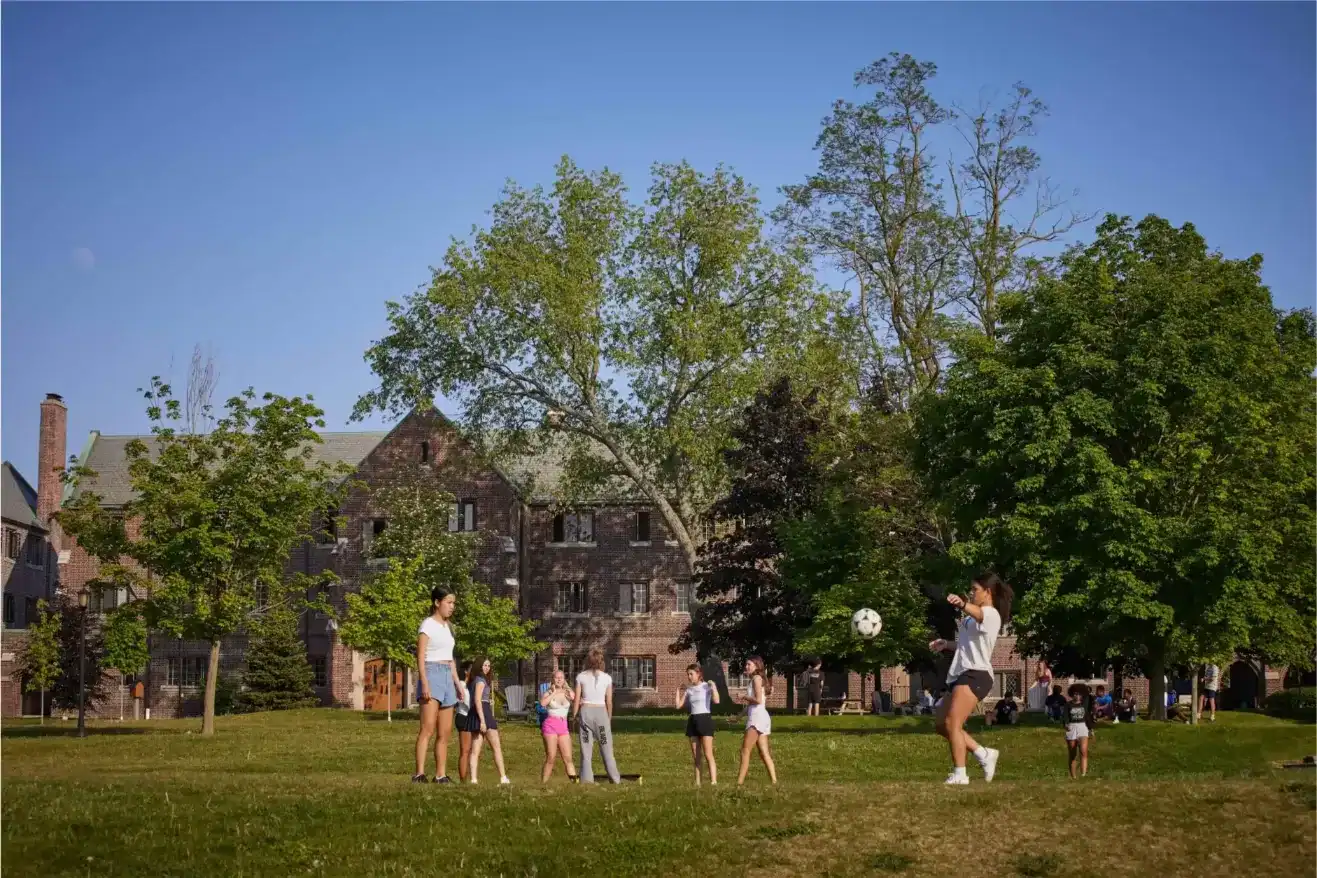 Children playing soccer on a lush green field at Trinity College School.