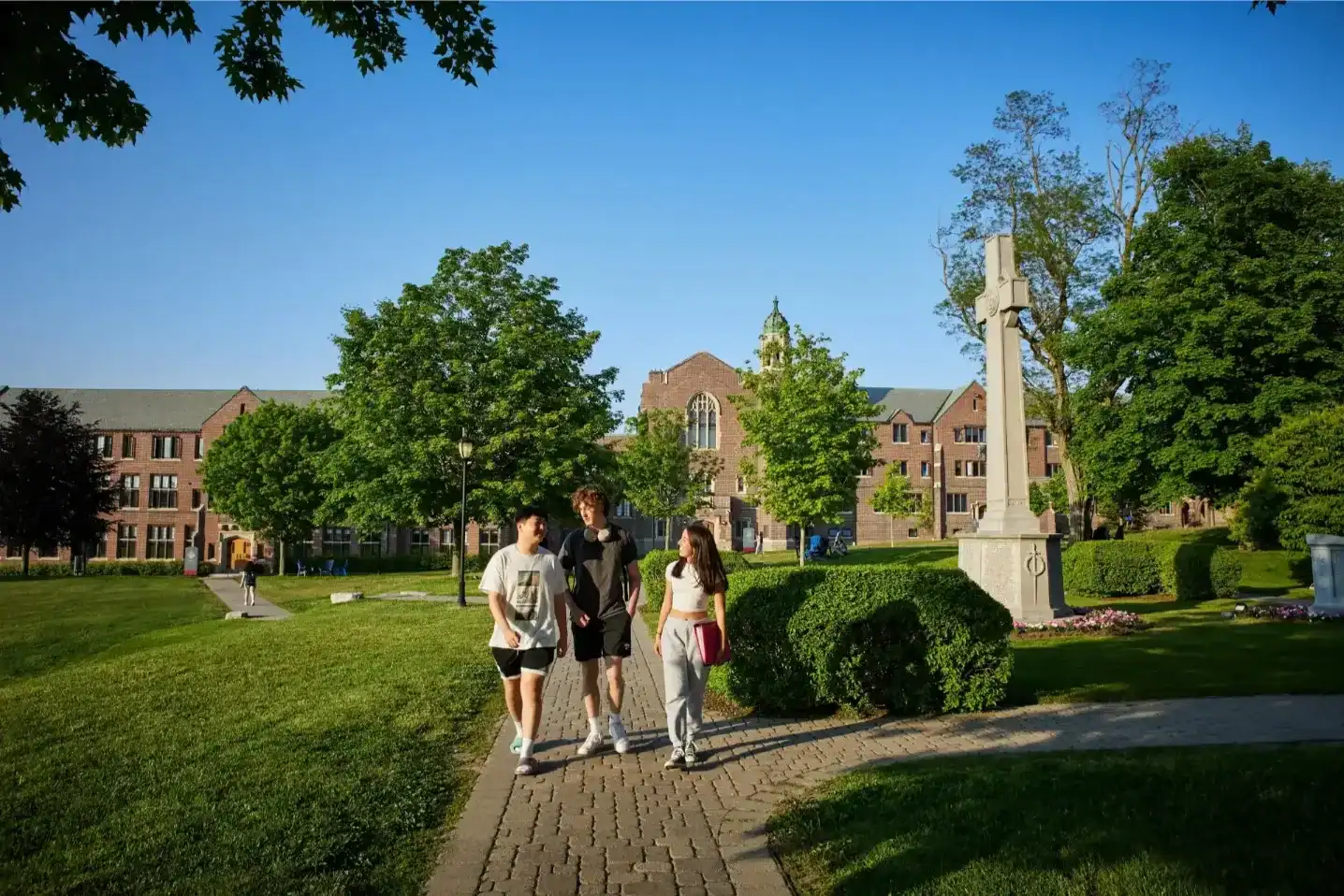 Students walking on campus at Trinity College School in bright sunlight.