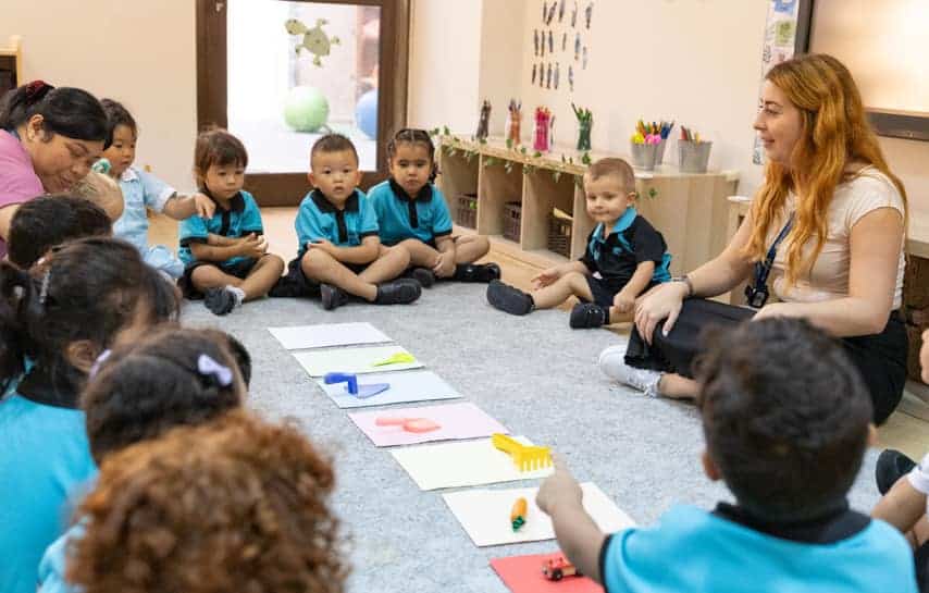 Bright preschool classroom with children learning in a circle during educational activity.