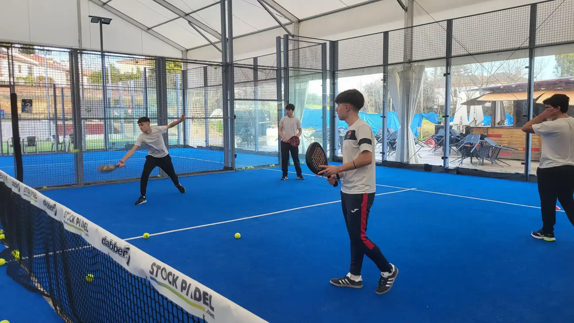 Playing tennis on an indoor court at a world school sports facility.