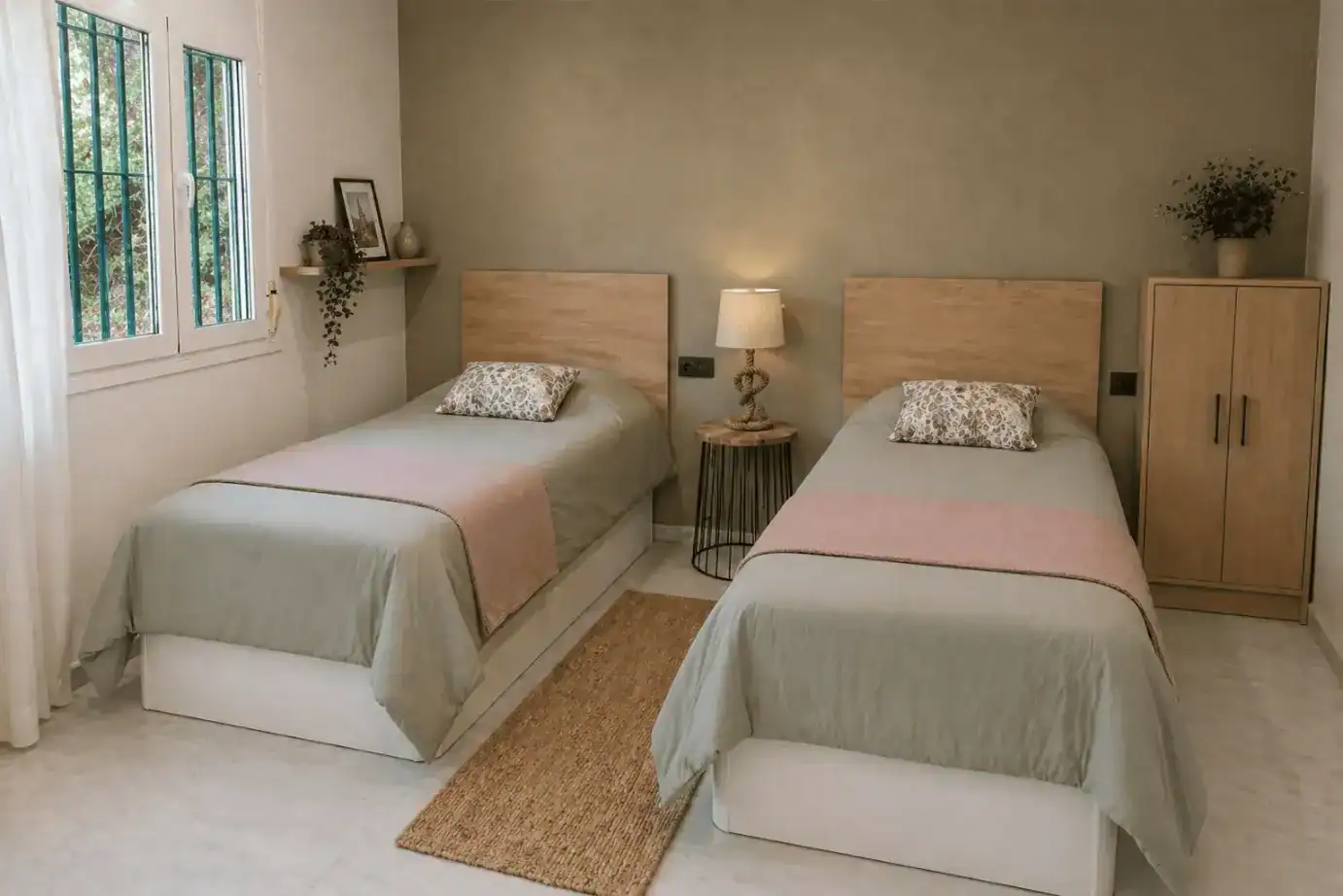 A comfortable twin bedroom with natural light and minimalist decor at The British School of Córdoba.