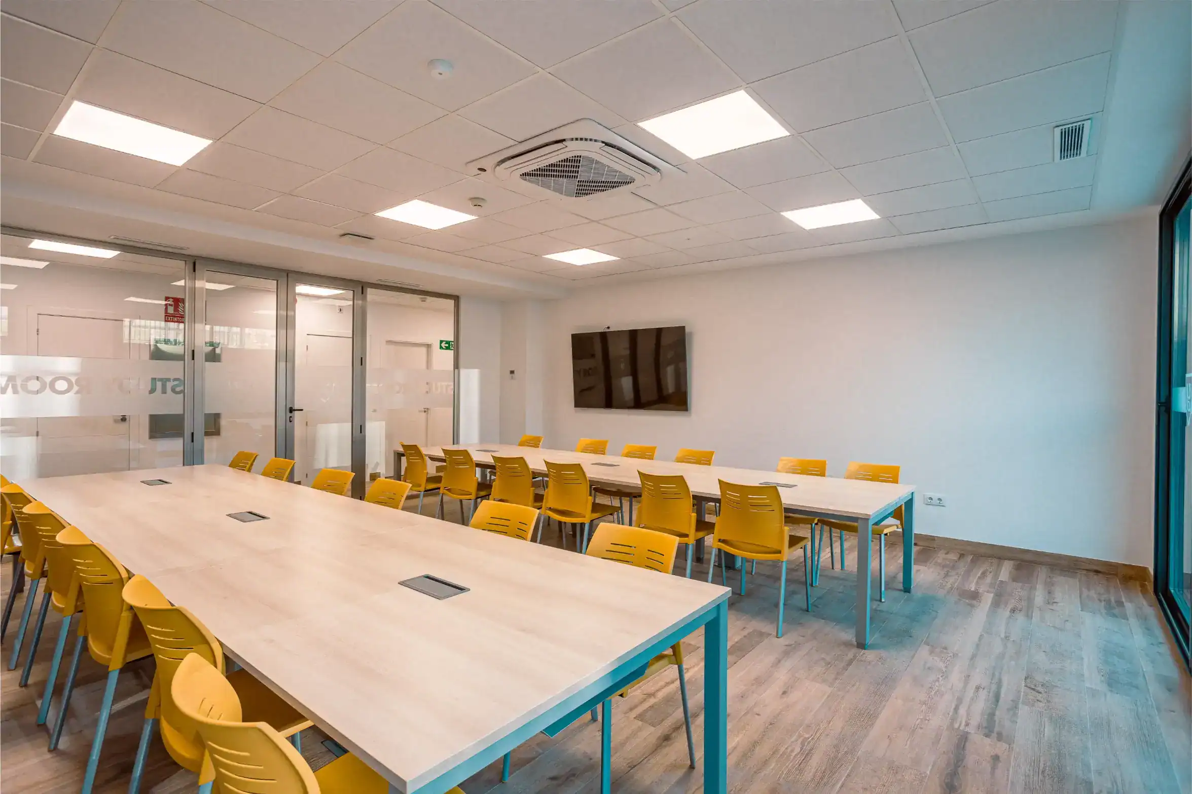 Bright modern classroom at World Schools with yellow chairs and smart technology setup for optimal learning.