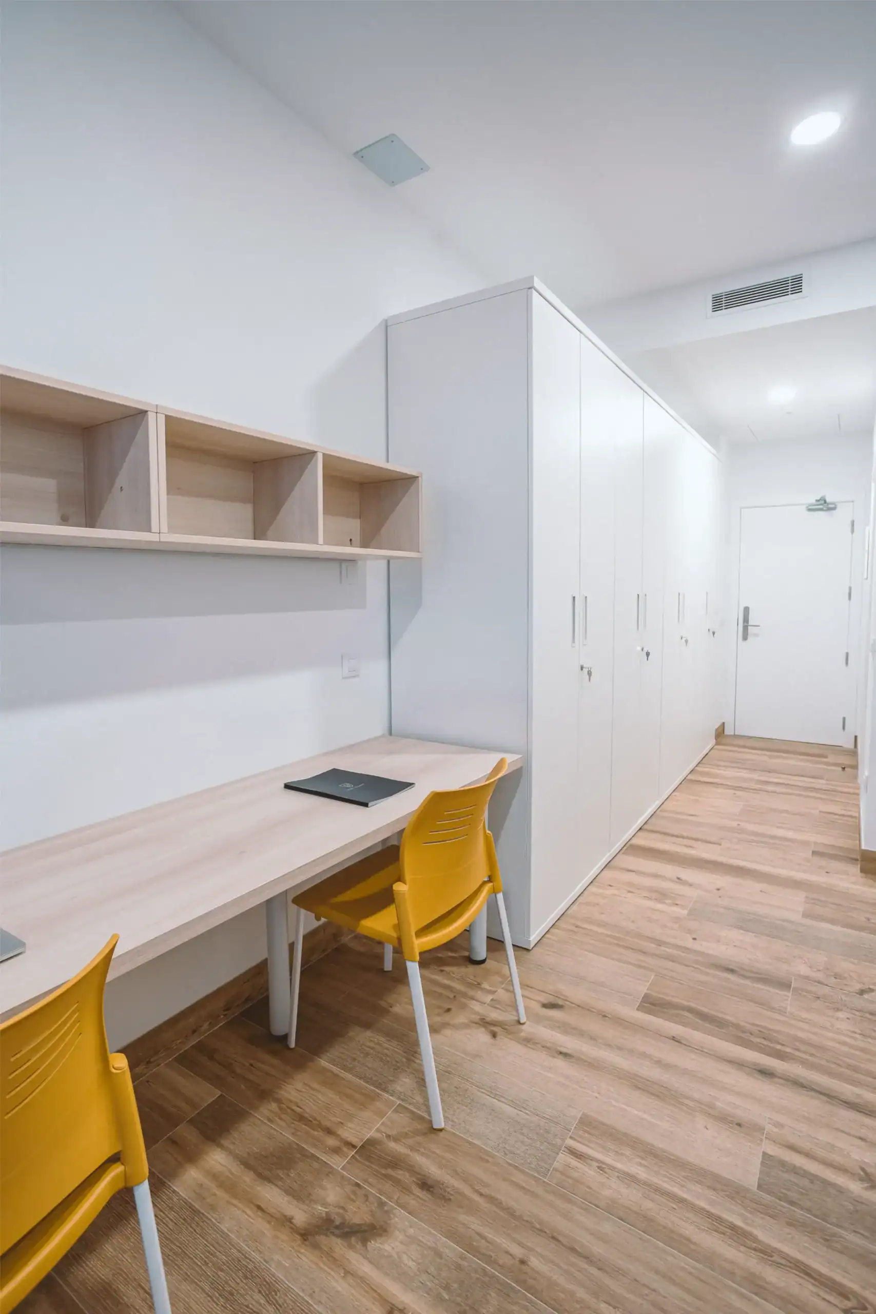 Modern school study area with white cabinets and yellow chairs for optimal learning environment.