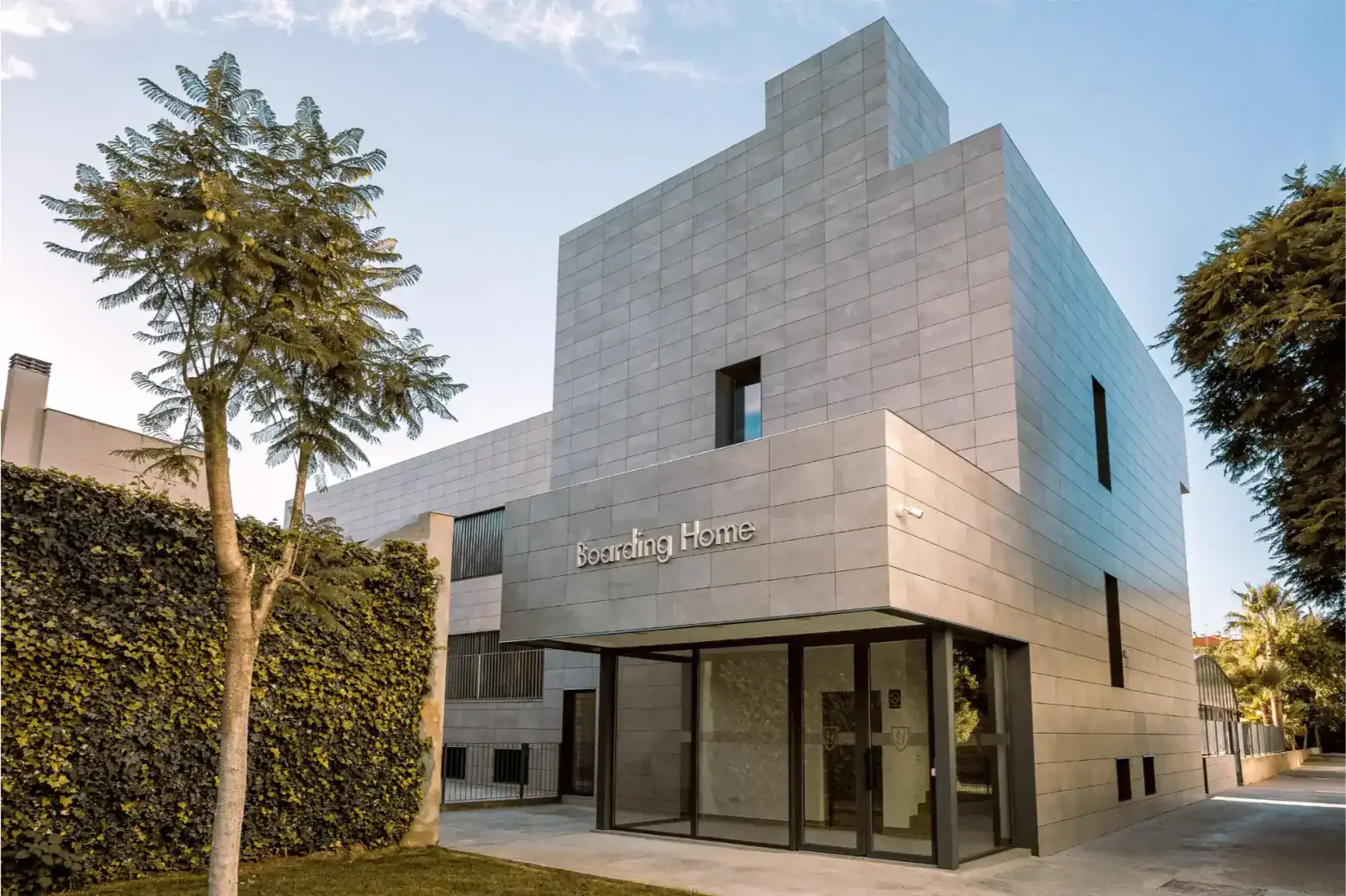 Modern international school building with sleek design and greenery, promoting global education excellence.