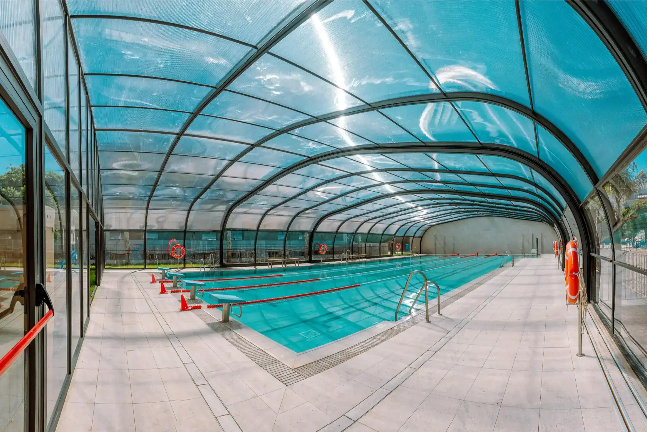 Indoor swimming pool at a World Schools sports facility, showcasing modern design and safety features.