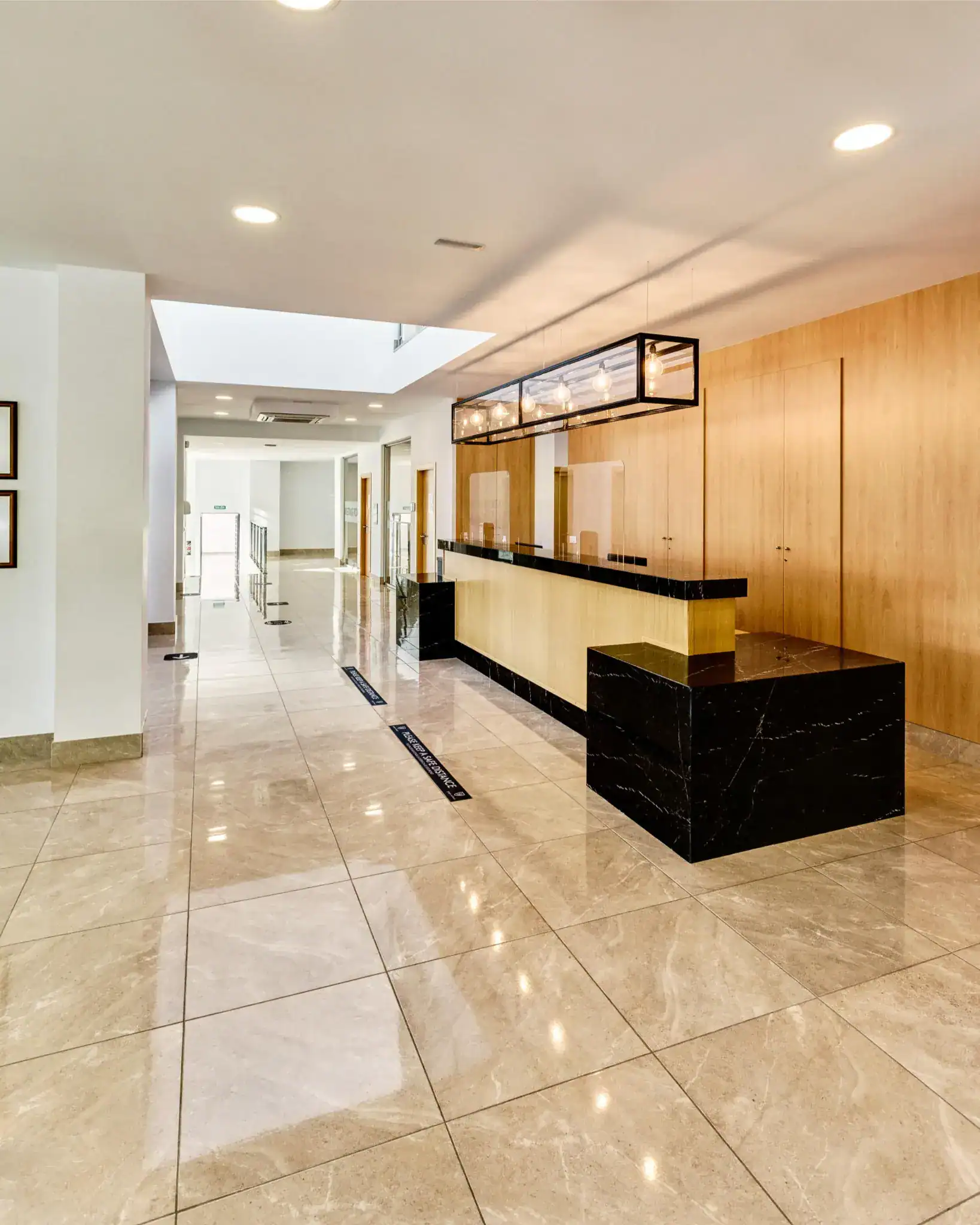 Bright modern school reception area with sleek design, wood accents, and polished tile flooring.