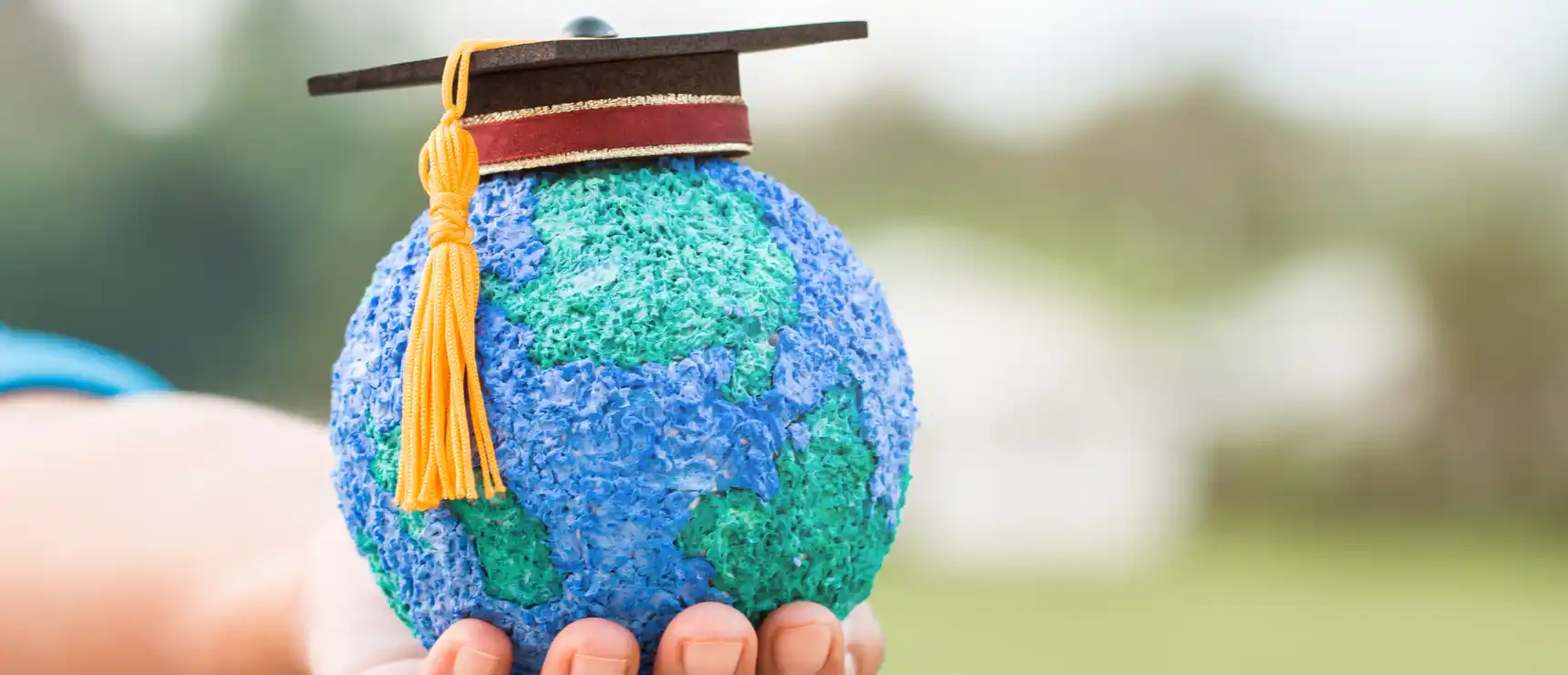 Mini globe dons graduation cap, symbolizing global education and international schools. What defines an International School: a guide for parents International School: Everything you need to know - World Schools