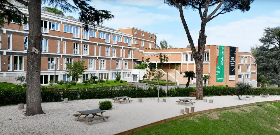 Modern international school campus with lush greenery and outdoor learning spaces.