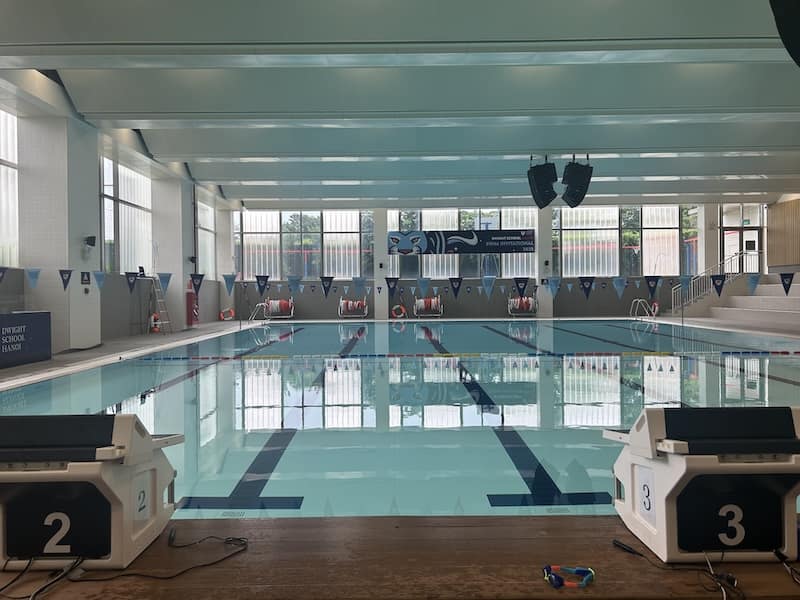 Indoor swimming pool with lanes and starting blocks at Dwight School Hanoi.