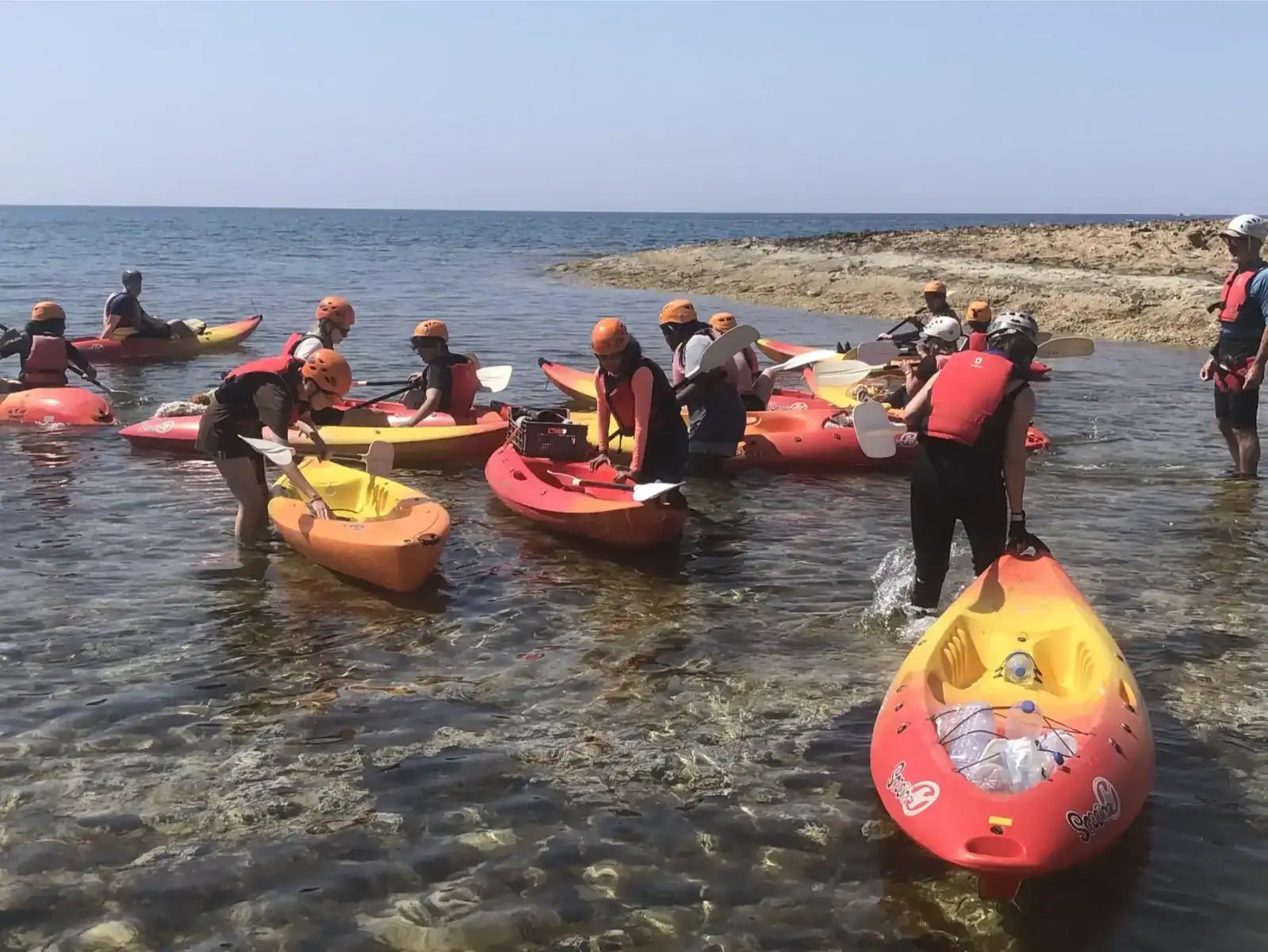 Enjoying kayaking at the beach with students in a safe, educational outdoor activity. Perfect for pr.