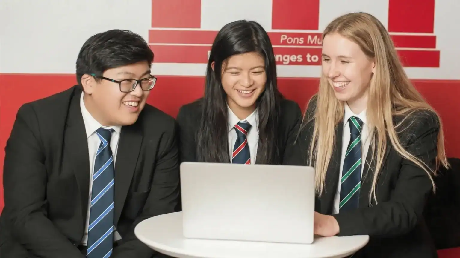 Dulwich College Shanghai Pudong students collaborating on a project with a laptop.