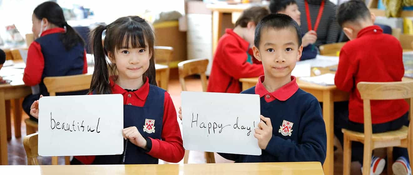 Students holding signs with positive messages in classroom.
