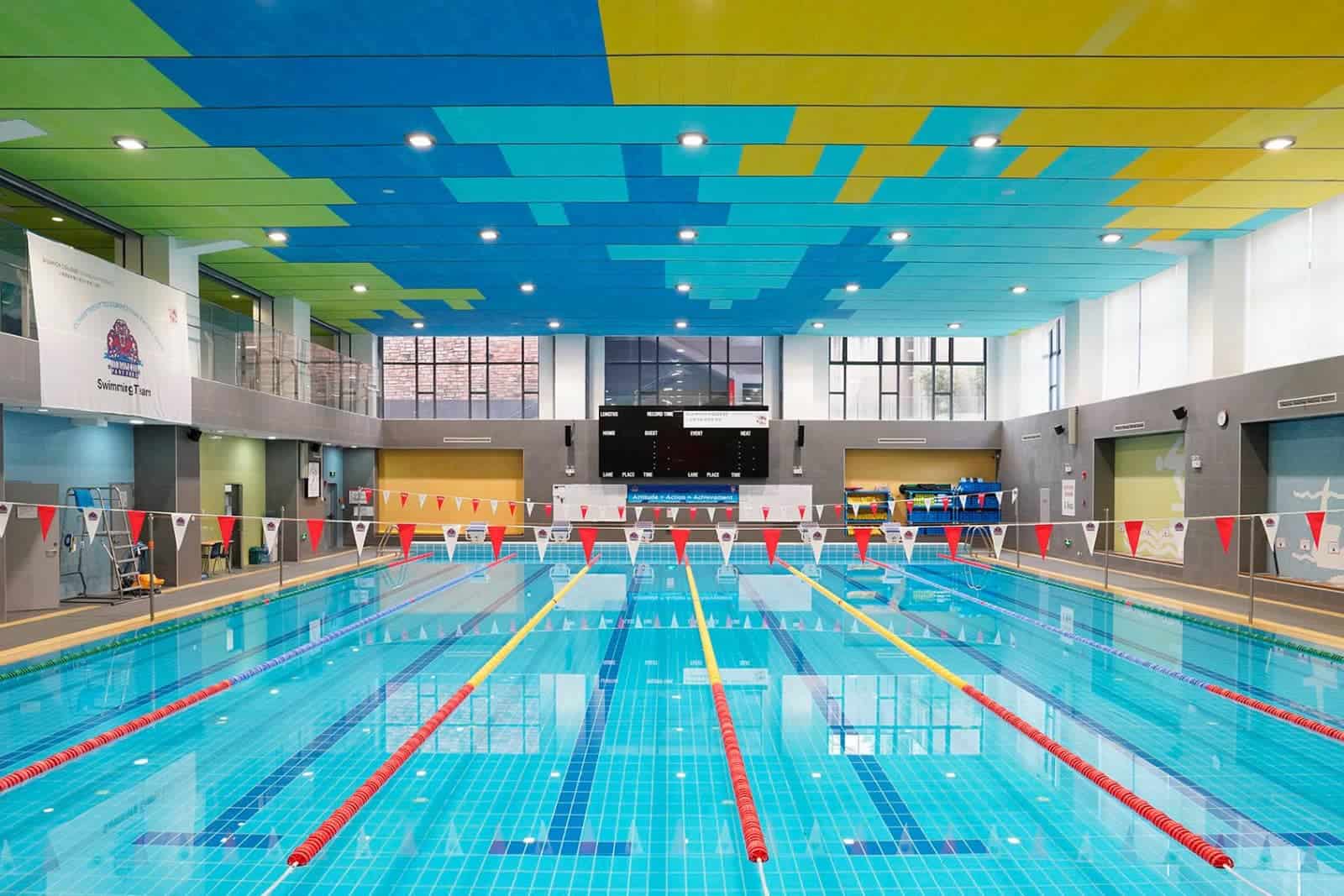 Indoor swimming pool at Dulwich College Shanghai Pudong with vibrant ceiling design and professional.