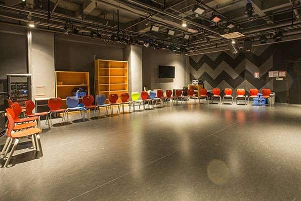 Bright, spacious school auditorium with colorful chairs and modern design.